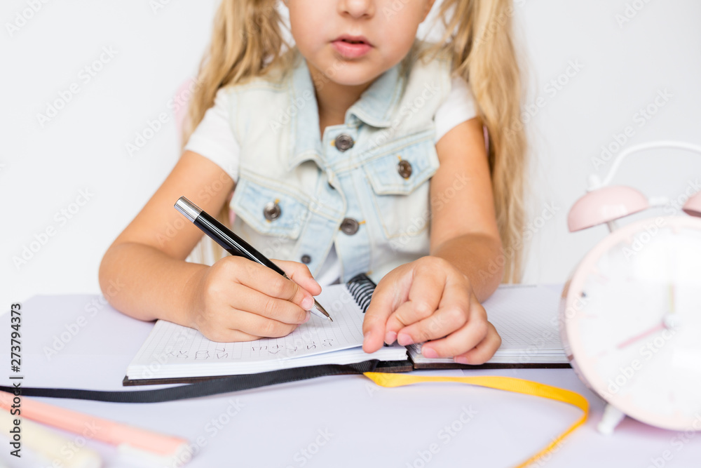 Back to school and happy time. Children holding pen and writting in notebook on white background. Kid making homework. Mockup, place for text, education concept Back to school and happy time. Children holding pen and writting in notebook on white background. Kid making homework. Mockup, place for text, education concept
