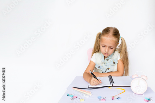 Back to school and happy time. Children holding pen and writting in notebook on white background. Kid making homework. Mockup, place for text, education concept