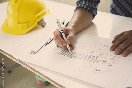 architect man handwriting with blueprint to build houses. After agreeing the employment price the cost of construction and repair real estate