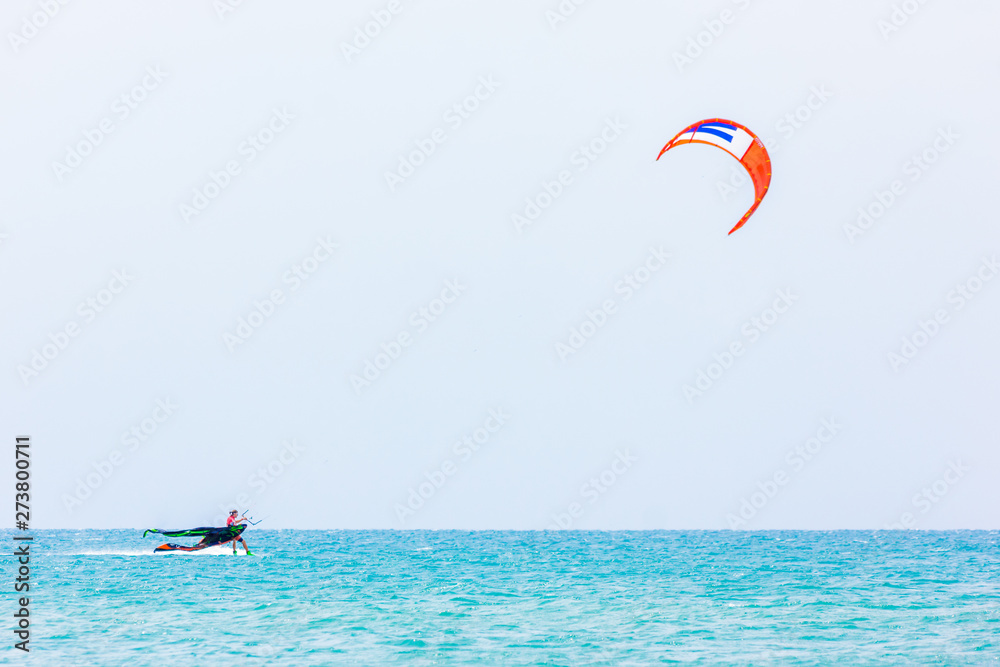 brave man kite sailing on the black sea with a sail wing in his hands led by the wind on a bright sunny day. village of the annunciation. сopy space.