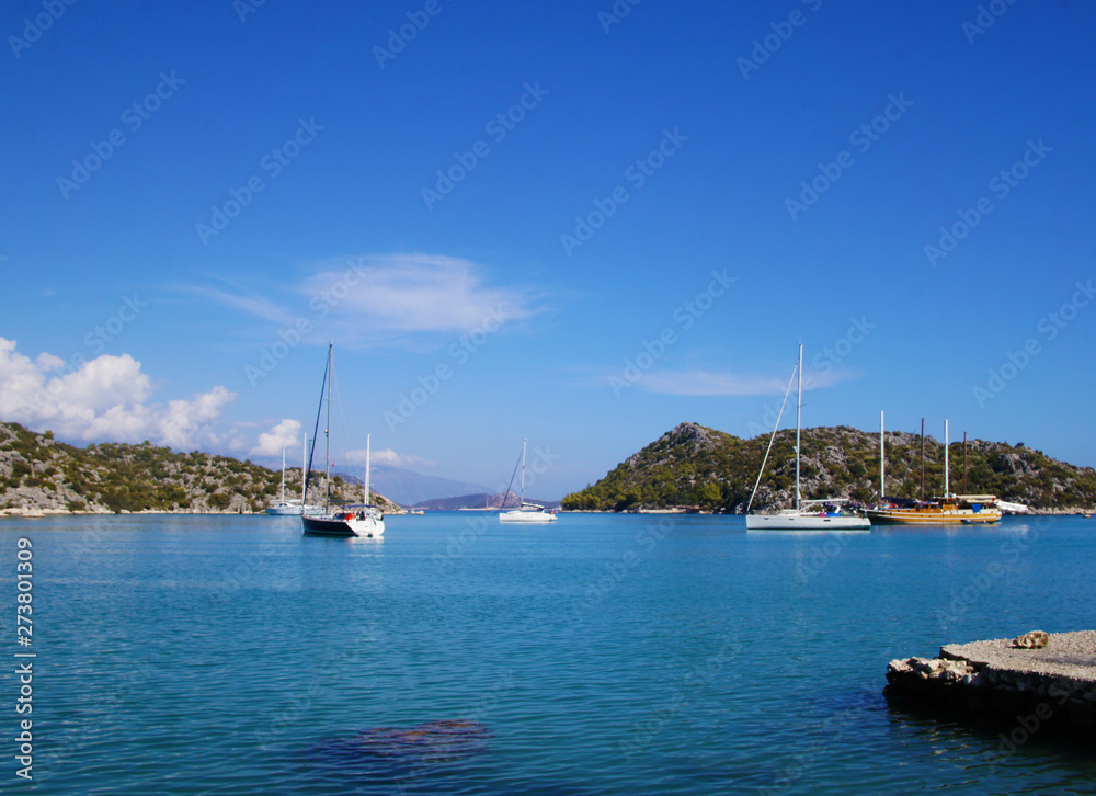 Blue lagoon with yachts. Ships stand near the shore against the backdrop of a beautiful landscape.