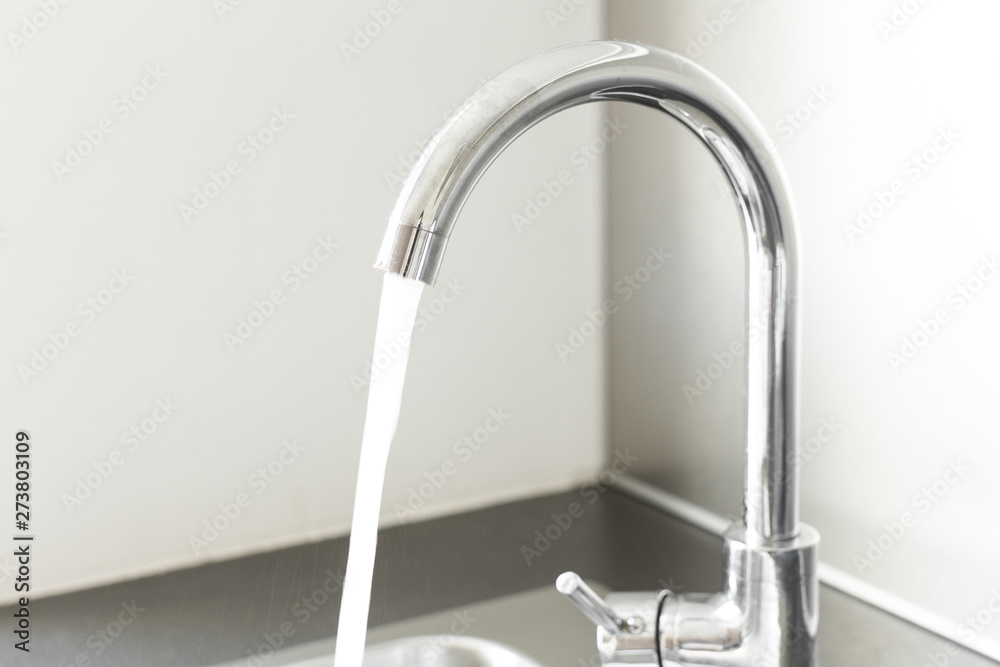 Mixer tap with water flowing. Chrome faucet and washbasin Mixer tap with water flowing. Chrome faucet and washbasin