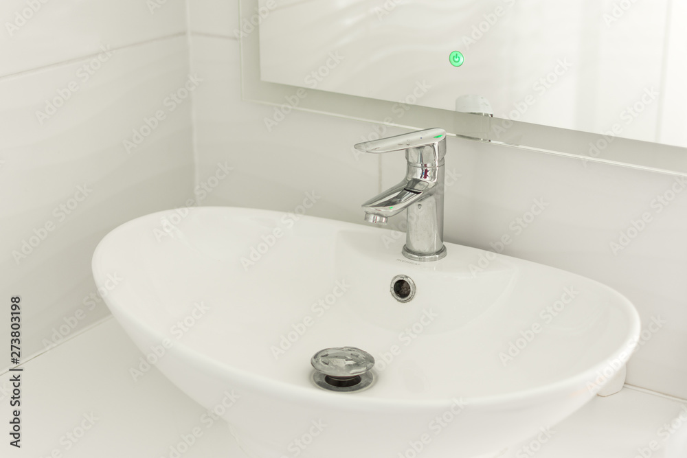Chrome faucet, sink and washbasin. Modern white bathroom interior. Chrome faucet, sink and washbasin. Modern white bathroom interior.