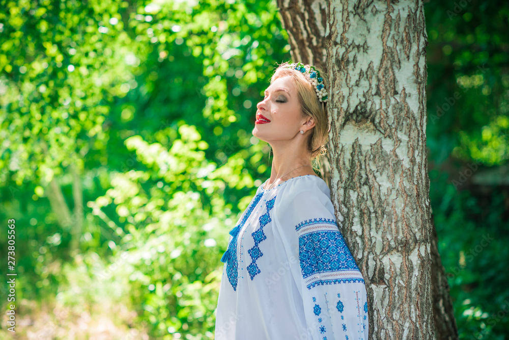 Pretty woman in traditional embroidered shirt with blue elements. Slavic culture Pretty woman in traditional embroidered shirt with blue elements. Slavic culture