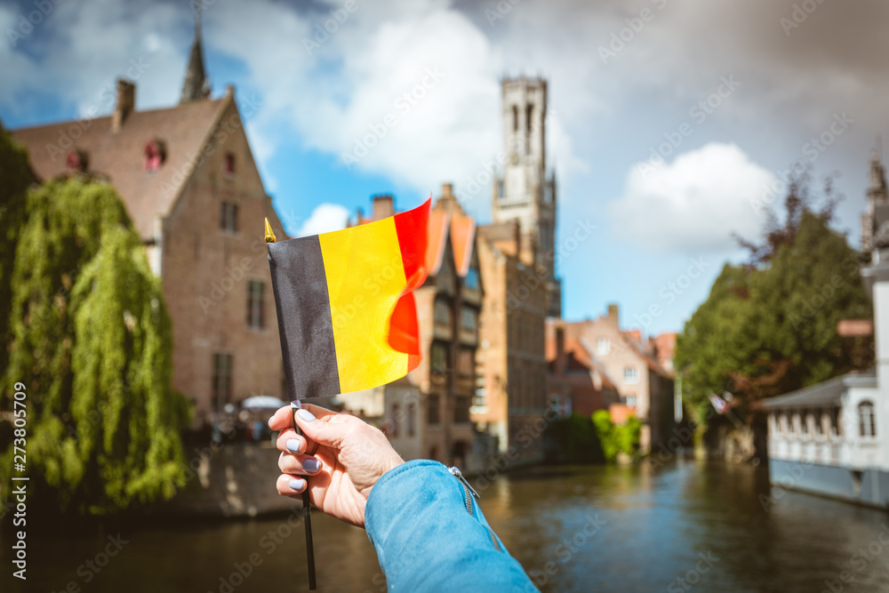 Fototapeta premium Flag of Belgium against the background of attractions in Bruges, Belgium