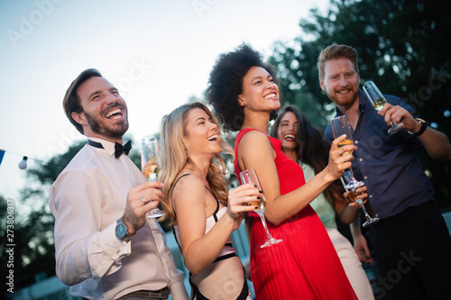 Group of friends at party dancing and smiling together