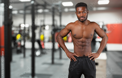 Cheerful handsome African sportsman with muscular strong body smiling to the camera