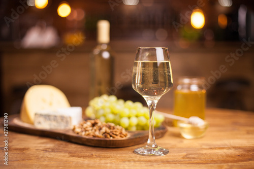 Photo of a sparkling white wine on a rustic wooden table in a vintage pub