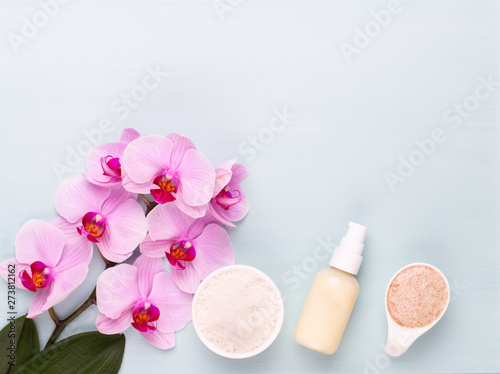 Sea salt, aromatherapy oil in bottles and orchid on vintage wooden background. © gitusik