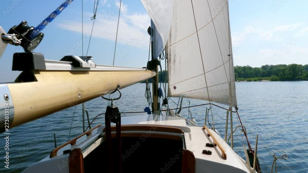 Small sailing boat with white sails on the river. Small sailing boat with white sails on the river.