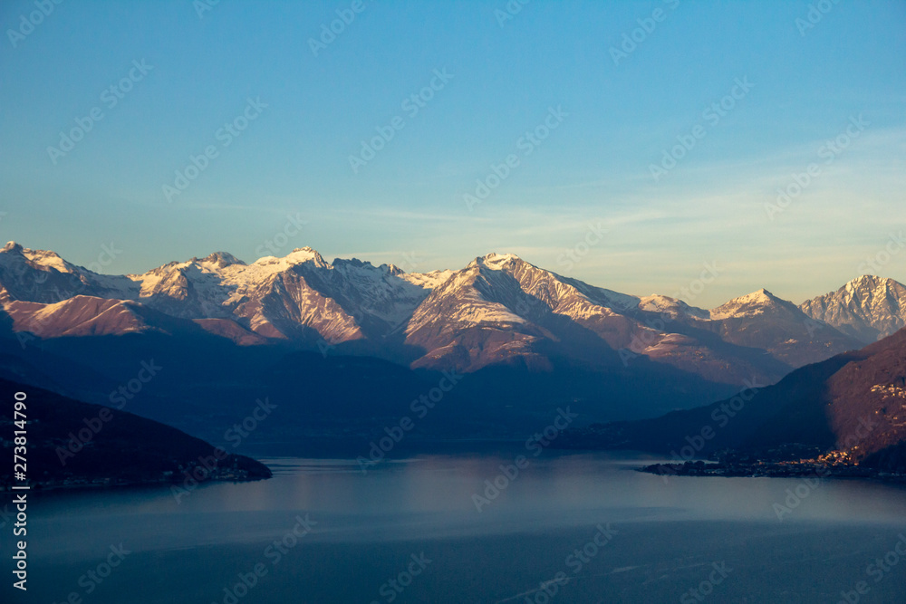 Flight over Lake Como at sunset. View of the mountains (Alps) in the light of the setting sun. Italy