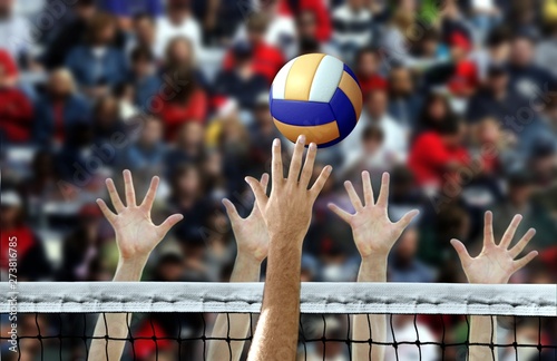 Volleyball spike with hands blocking over the net