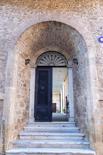  Entrance of the old stone house with black metal door and evil eye hanged near it. © borabalbey