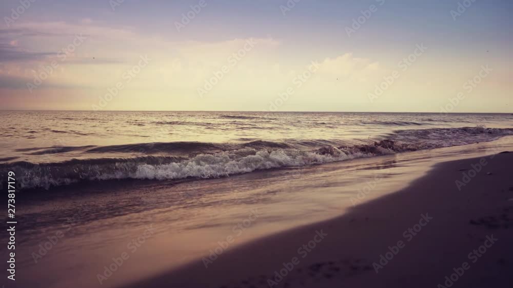 Blue ocean waves lapping over empty beach. Amazing sunset landscape. Slow motion footage. Steadicam. Blue ocean waves lapping over empty beach. Amazing sunset landscape. Slow motion footage. Steadicam.