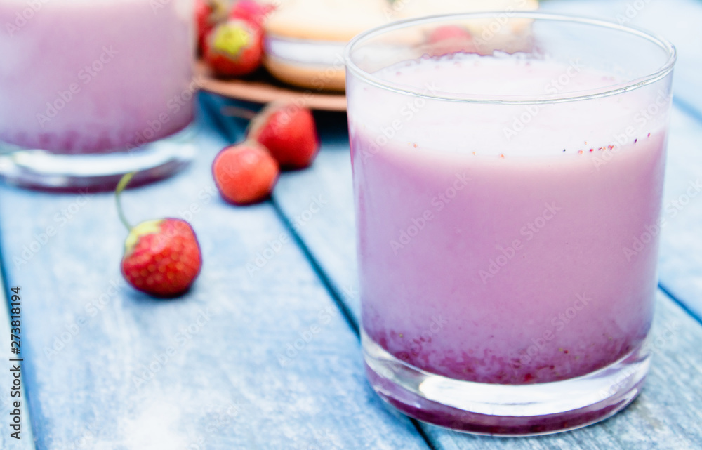 Cocktail with milk and berries club in a glass against the background of blue boards. Cocktail with milk and berries club in a glass against the background of blue boards.