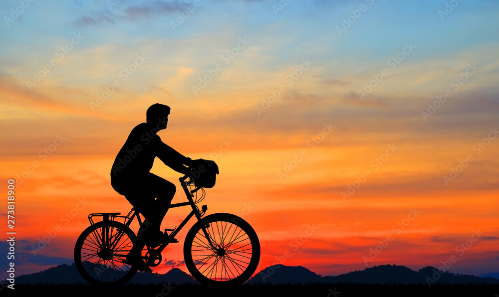 Obraz premium Silhouette man and bike relaxing on blurry sunrise sky background.