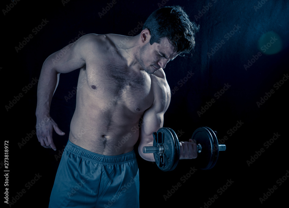 young muscular man lifting weights over dark background