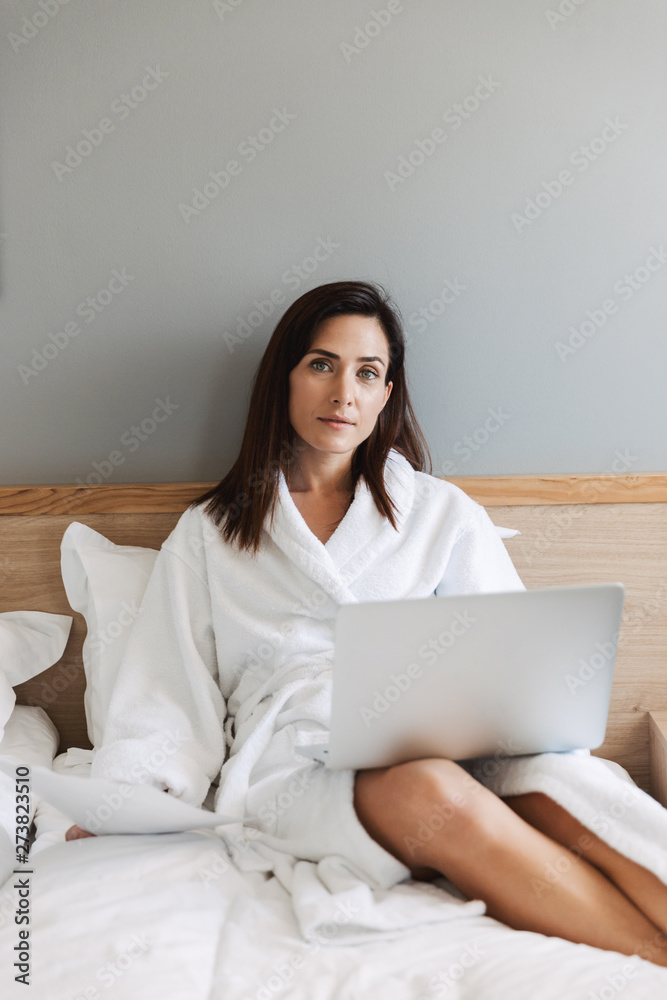 Beautiful young business woman indoors at home using laptop computer. Beautiful young business woman indoors at home using laptop computer.