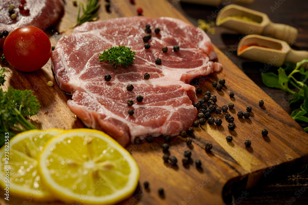 A piece of meat is prepared for making a steak for the family dinner.Steak and ingredients prepared for the evening party A piece of meat is prepared for making a steak for the family dinner.Steak and ingredients prepared for the evening party