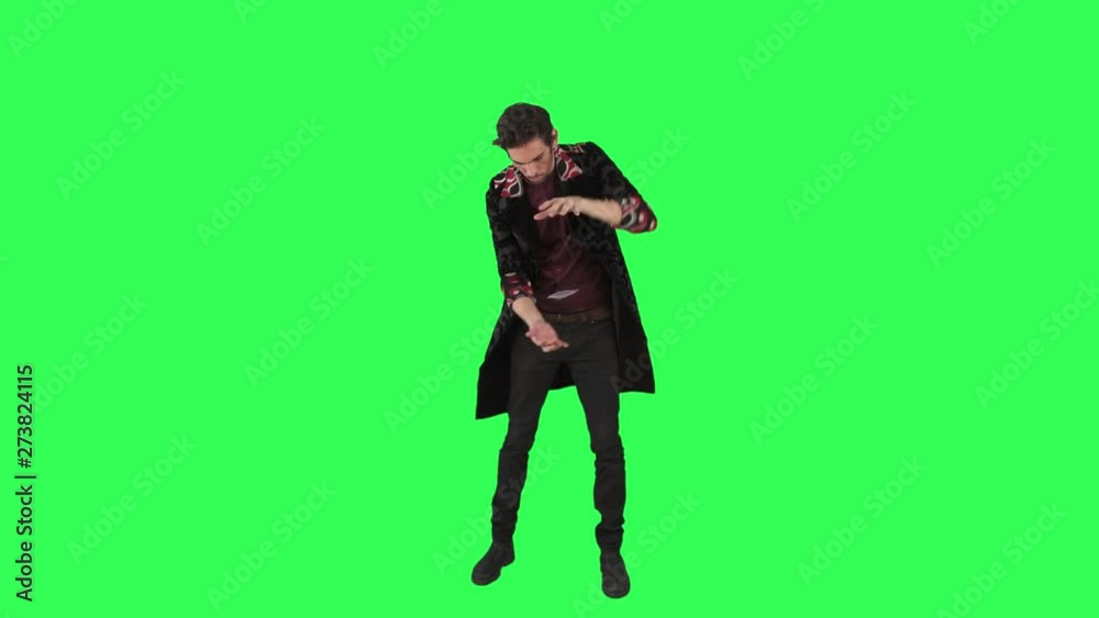 A magician performs a magic trick of a flying card over a green screen, A magician performs a magic trick of a flying card over a green screen,