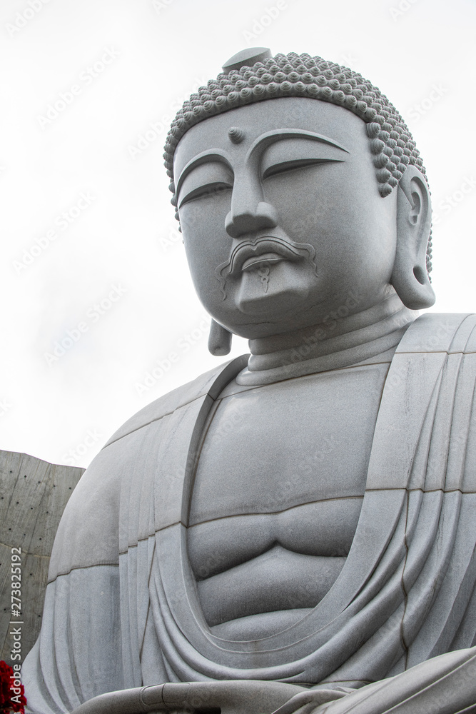 Closeup of sitting & peaceful giant Buddha statue inside Hill of the Buddha, Buddhist shrine at Makomanai Takino Cemetery, Sapporo, Hokkaido, Japan. Designed by Tadao, a Japanese modernist architect.