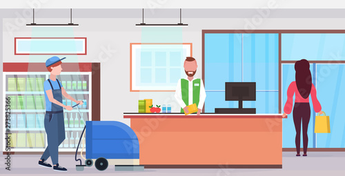 man using professional washing machine cleaner supermarket janitor in uniform cleaning service concept modern store counter desk grocery shop interior flat full length horizontal