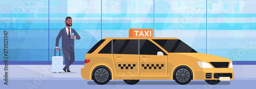 businessman using mobile app ordering taxi on street african american business man in formal wear with luggage near yellow cab city transportation service concept full length flat horizontal