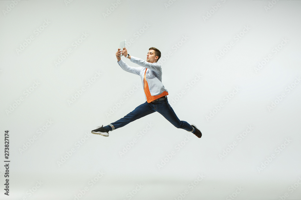 Happy young man working at office, jumping and dancing in casual clothes or suit isolated on white studio background. Business, start-up, working open-space, ballet or professional occupation concept.
