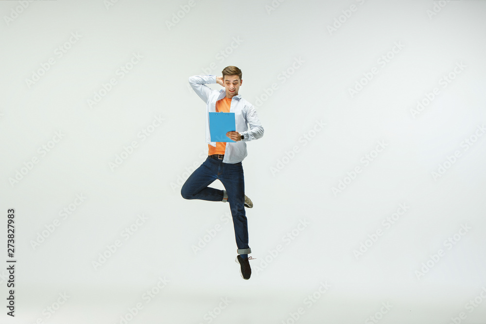 Happy young man working at office, jumping and dancing in casual clothes or suit isolated on white studio background. Business, start-up, working open-space, ballet or professional occupation concept. Happy young man working at office, jumping and dancing in casual clothes or suit isolated on white studio background. Business, start-up, working open-space, ballet or professional occupation concept.