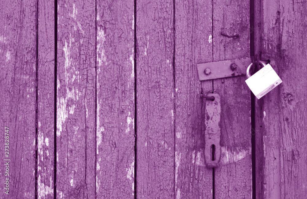 Old padlock on wooden gate in purple tone. Old padlock on wooden gate in purple tone.