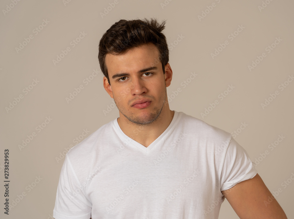 Natural portrait of young attractive man in his 20s looking and posing with neutral face expression Natural portrait of young attractive man in his 20s looking and posing with neutral face expression