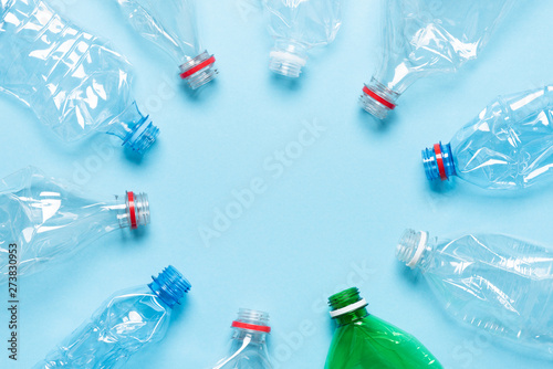 Plastic bottles on blue background top view. Recycle plastic waste pollution concept.