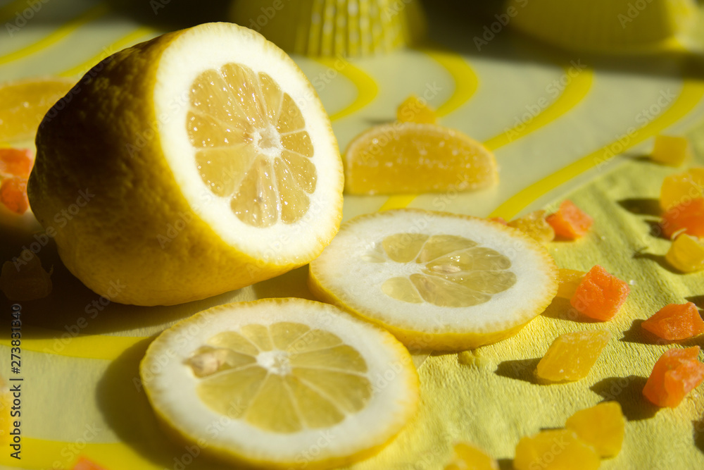 Lemon with candied fruit on a yellow background; photo for text