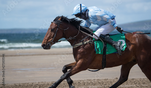 Galloping race horse and jockey on the beach © Gabriel Cassan