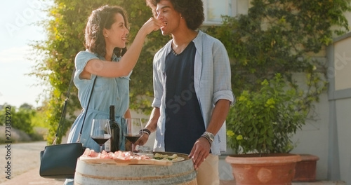 Romantic couple, man and woman with red wine eating appetizer at warm sunset.Medium shot. Friends italian trip in Umbria.4k slow motion