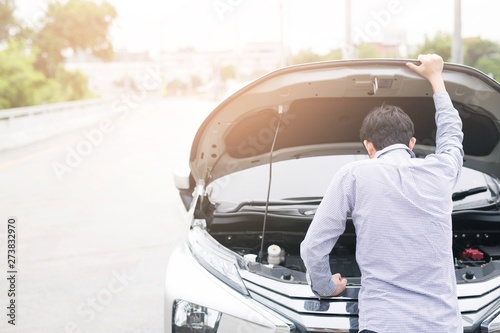 Men are stressed because the car is broken by the way, waiting for help photo