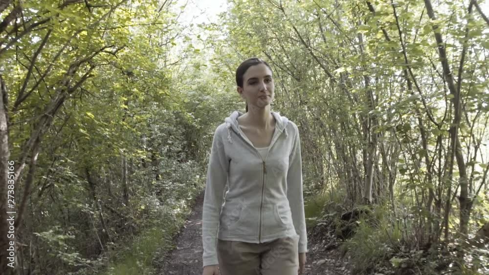 Relaxed young woman walking in nature alone