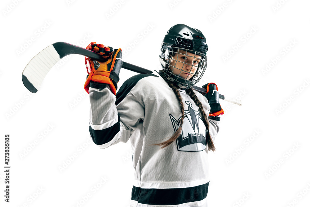 Young female hockey player isolated on white background. Sportswoman wearing equipment and helmet standing with the stick. Concept of sport, healthy lifestyle, motion, movement, action.
