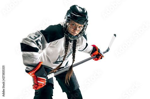 Young female hockey player isolated on white background. Sportswoman wearing equipment and helmet standing with the stick. Concept of sport, healthy lifestyle, motion, movement, action.