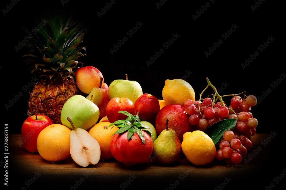 still life of fresh fruit lying on dark wood background