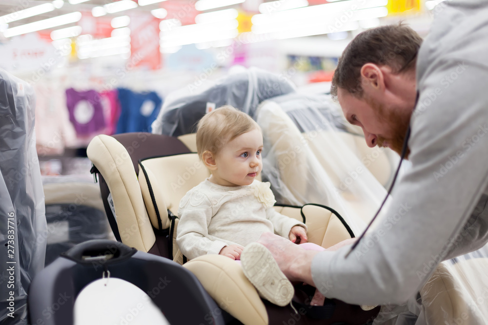 Obraz premium Dad with baby in store buying car seat.