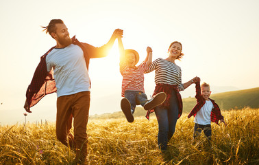 Happy family: mother, father, children son and daughter on sunset.