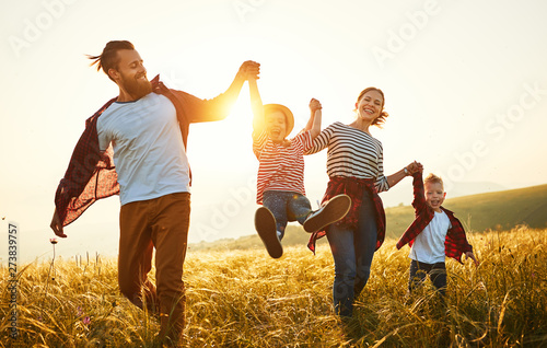 Happy family: mother, father, children son and daughter on sunset.
