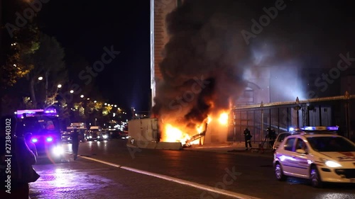 Paris, France - April 6, 2019: Fire in Paris with cars and firemens near Museum. Firefighter, Dark Smoke, burning fire, monument. Fireman running and policeman in police car passing by with speed. photo