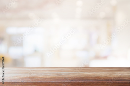 Empty wood table top on blur bokeh cafe and restaurent interior background - can be used for display or montage your products