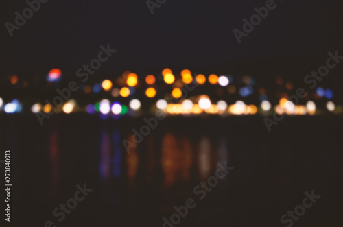 Abstract colorful bokeh effect city lights reflected over night water outdoor background. - Image