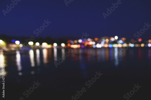 Abstract colorful bokeh effect city lights reflected over night water outdoor background. - Image © ireneromanova