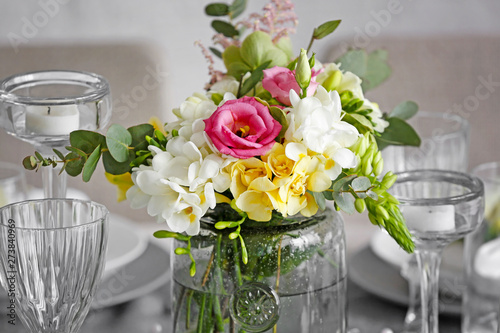 Beautiful bouquet with fresh freesia flowers on served table