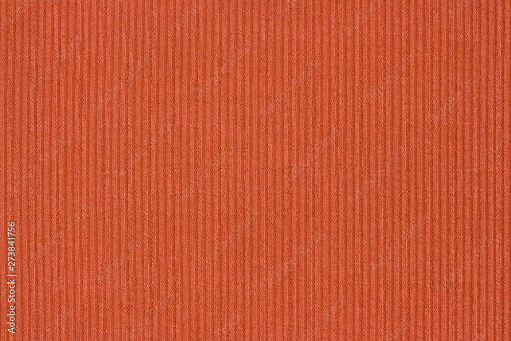 Fototapeta premium Ribbed textile material, in fine-knit stretch fabric. Knitwear texture. Burnt orange color background.