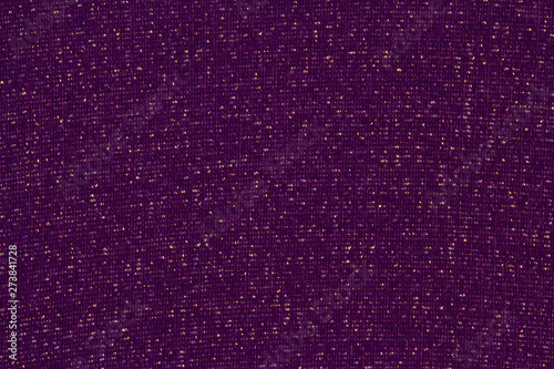Dark violet textile background with a metallic Lurex gold thread. Plum matte fabric interspersed with shiny sequins. photo